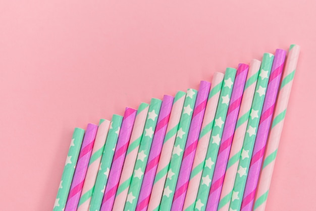 Colorful Paper coctail tubes on the pink background. Eco friendly. Zero Waste