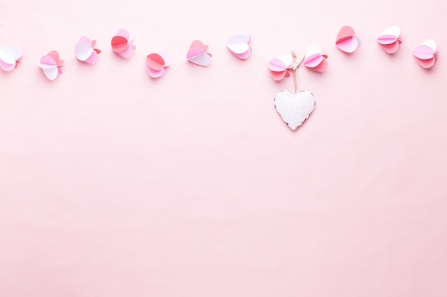 Colorful paper garland of hearts on the living coral background. Valentine day greeting cards.