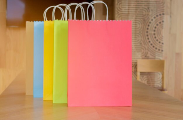 Photo colorful paper shopping bags on wooden tables for women concept fashion and shopping