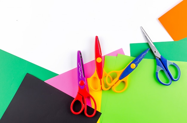 Colorful paper with scissors for children on a white