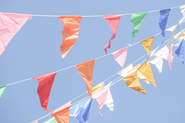 Colorful Party flags bunting hanging on blue sky for holiday decoration