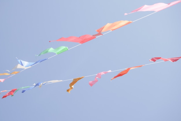 Colorful Party flags bunting hanging on blue sky for holiday decoration