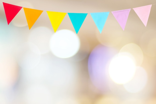 Colorful party flags hanging on blur abstract background