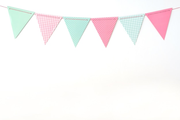 Colorful party flags hanging on white wall  background, birthday, anniversary card backgro