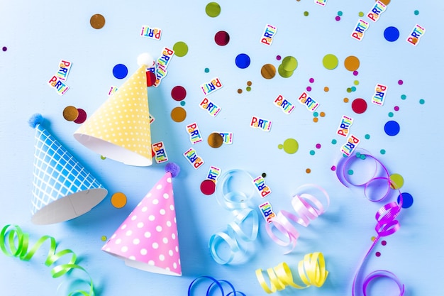 青い背景の子供たちの誕生日パーティーのためのカラフルなパーティーハット。