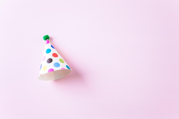 Colorful party hats for kids Birthday Party on pink background.