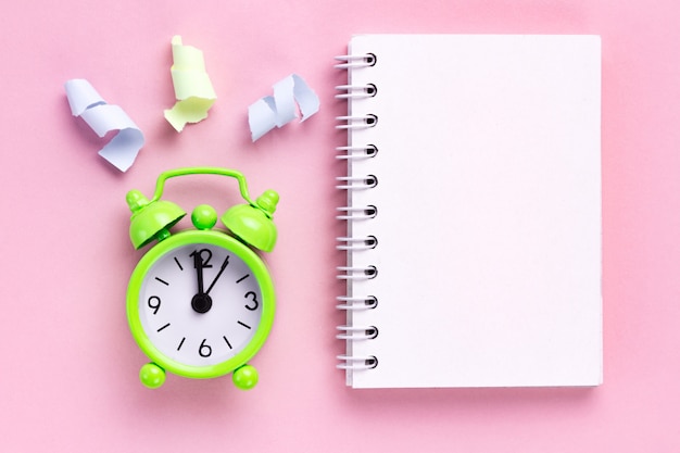 Photo colorful party streamers and a alarm clock on a pink background