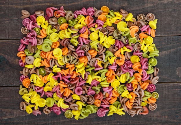 Colorful pasta on a dark rustic wooden table