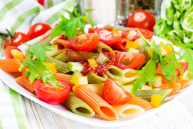 Pasta colorata su un piatto bianco su un legno