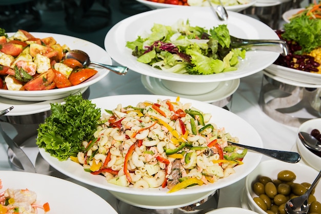 Colorful pasta on a white plate on a wooden