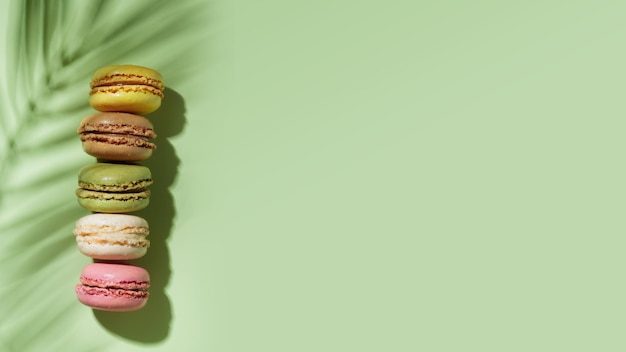 Colorful pastel eco handmade macaroons on green background with a shadow Gift for 8 March International Women's Day Valentine Day