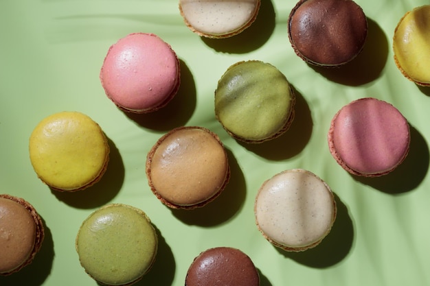 Colorful pastel eco handmade macaroons on green background with a shadow Gift for 8 March International Women's Day Valentine Day