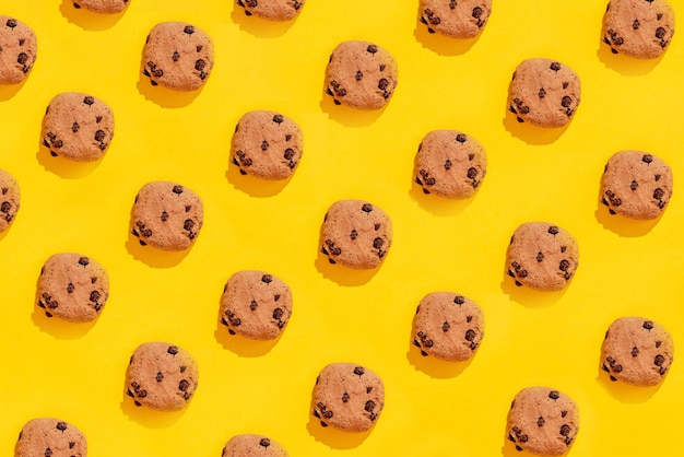 Colorful pattern of sweet cookies on yellow background top view flay lay