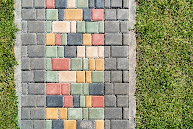 Colorful paved road across lush lawn on sunny day