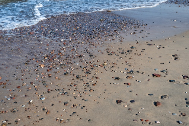 Colorful pebbles on the sand by the sea