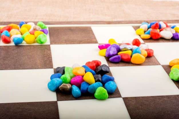 Colorful pebbles spread on checked board