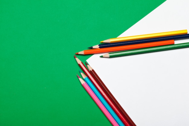 Colorful pencils on a bright green paper
