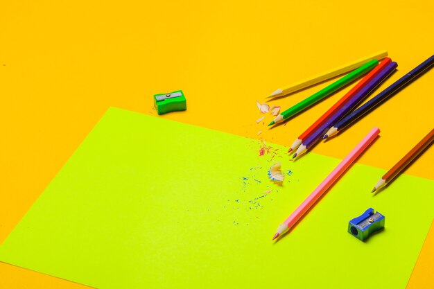 Colorful pencils on a bright green paper 