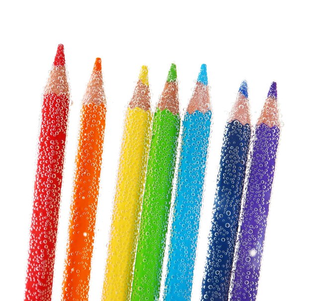 Фото Красочные карандаши в воде с пузырьками, изолированными на белом