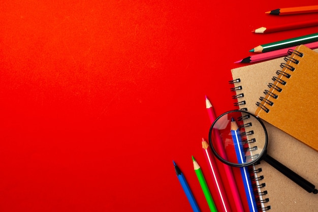 Colorful pencils and notepads on paper, flat lay