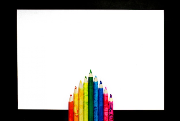 한 장의 종이에 다채로운 연필이 아름답게 놓여 있습니다.