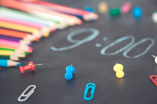 Photo colorful pencils with clock