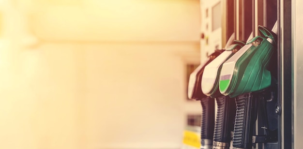 Colorful petrol and diesel nozzles of the dispenser machine at\
the gas fuel station