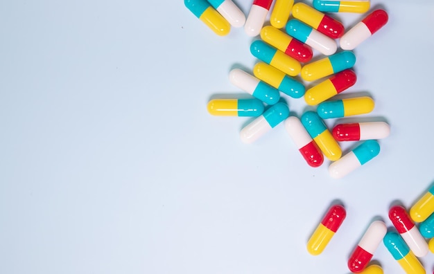 Colorful pills and capsules on blue background. Minimal medical concept. Pharmaceutical, Medicine.