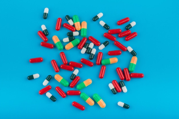 Colorful pills capsules on a blue background