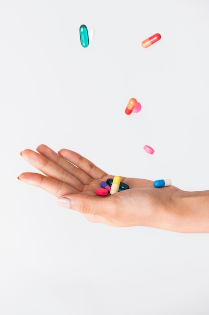 Photo colorful pills falling to a palm