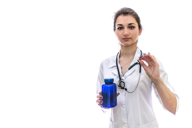 Colorful pills in female hands isolated on white wall