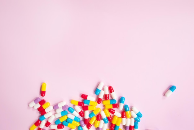 Colorful pills on a pink background.