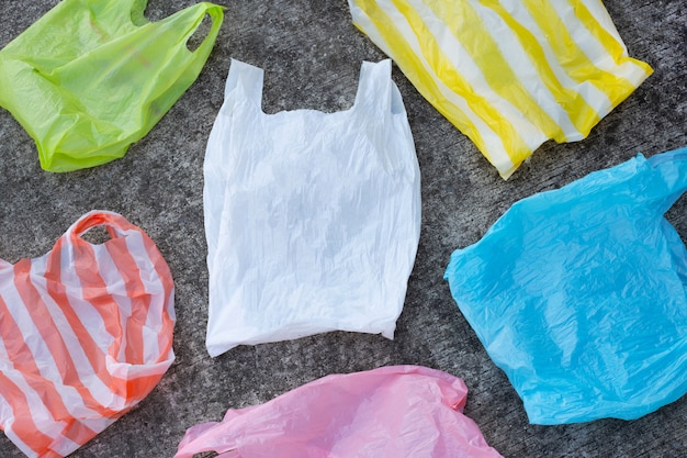 Colorful plastic bags on cement floor 