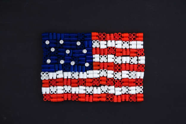 黒い紙の背景に米国旗を形成するカラフルなプラスチック製のレンガ