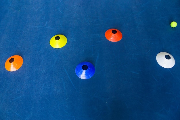 Colorful plastic cones on a blue cement tennis court Top view Horizontal photo