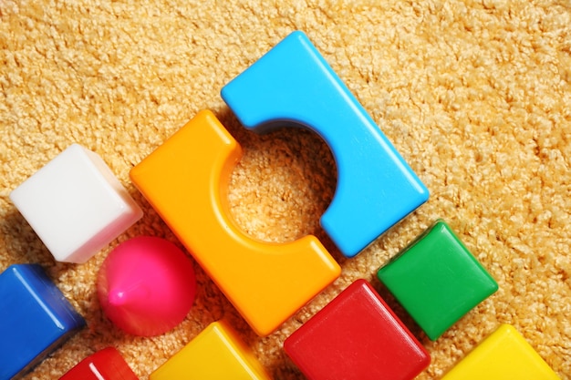 Colorful plastic kids toys on carpet