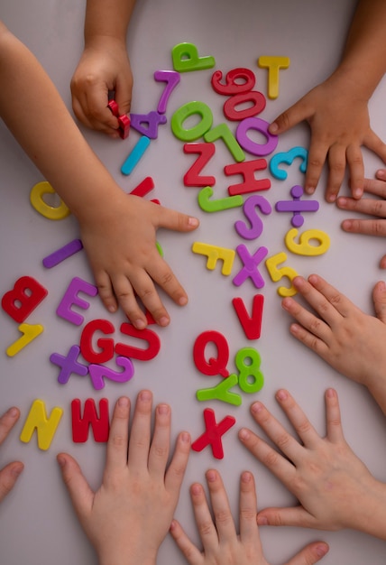 Photo colorful plastic letters and numbers in kids hands