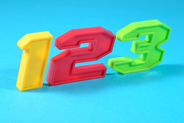 Colorful plastic numbers 123 on a blue background