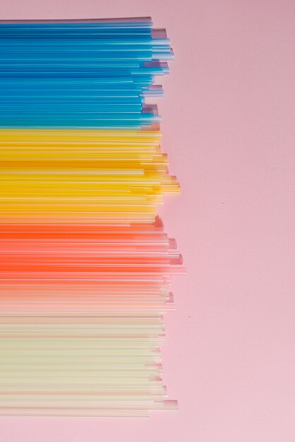 Photo colorful plastic straws on light background. event and party supplies. earth pollution concept