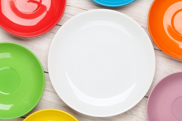 Colorful plates over wooden table