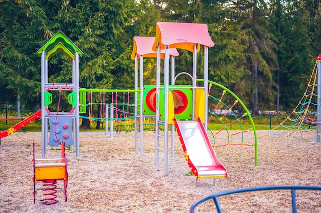 Foto parco giochi colorato in cortile nel parco attività colorate di parco giochi per bambini nel parco pubblico circondato da alberi verdi