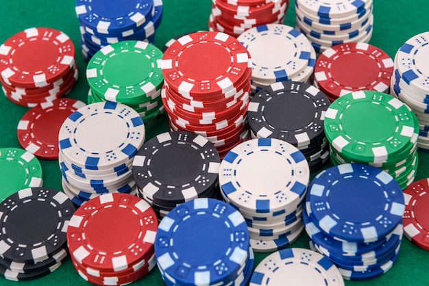Colorful poker chips on green table. Gambling concept, background