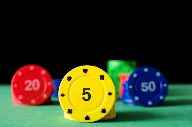 Colorful poker chips on poker table and black