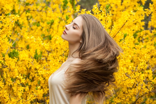 Colorful portrait of beautiful woman outdoors Cheerful girl on flowers background
