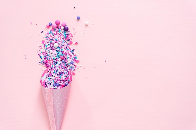 Colorful purple sprinkle blend on a pink background.