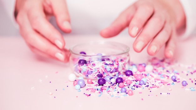 Colorful purple sprinkle blend on a pink background.