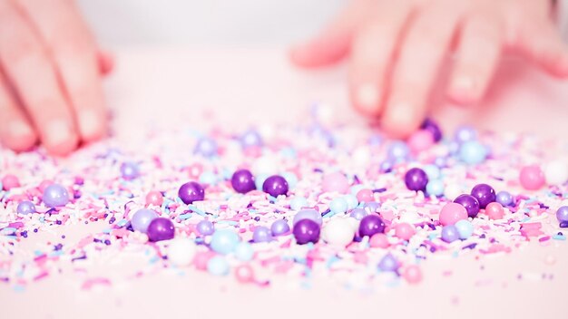 Colorful purple sprinkle blend on a pink background.