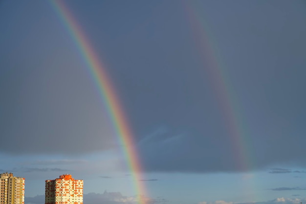 Colorful rainbow over the city. Beautiful rainbow at sunset