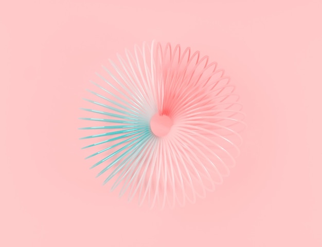 Colorful rainbow spiral plastic toy on pink background