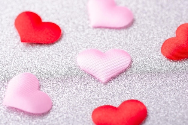 Colorful red and pink hearts on silver background